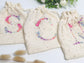 Cream-colored pouch with a golden floral initial