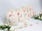Cream-colored pouch with a golden floral initial