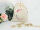 Cream-colored pouch with a golden floral initial
